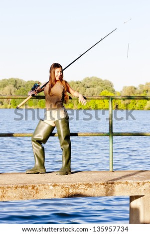 young woman fishing at pond