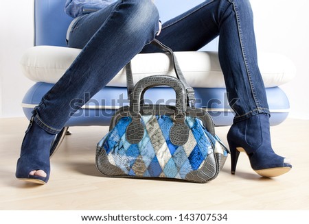 detail of woman wearing blue shoes and with handbag