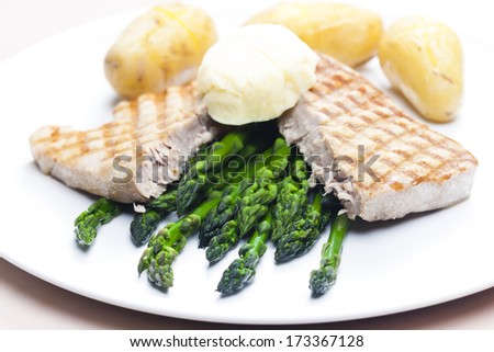 tuna steak with green asparagus and unpeeled potatoes