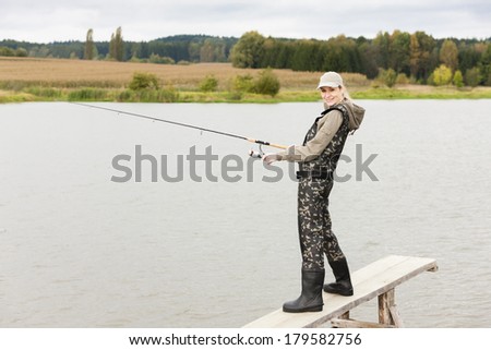 woman fishing on pier at pond
