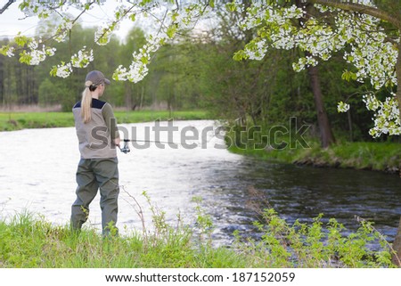 woman fishing by the river in spring