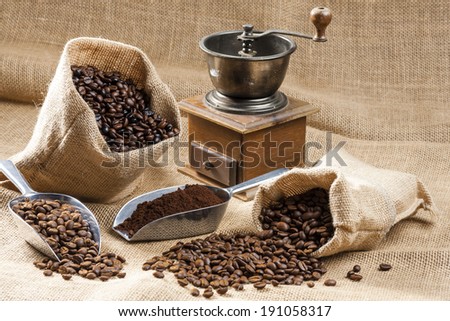 still life of coffee beans in jute bags with coffee grinder