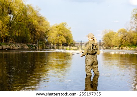 woman fishing in the river in spring