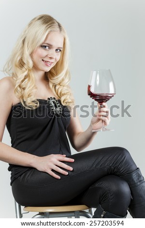 sitting young woman with a glass of red wine