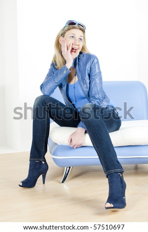 woman wearing blue clothes sitting on sofa