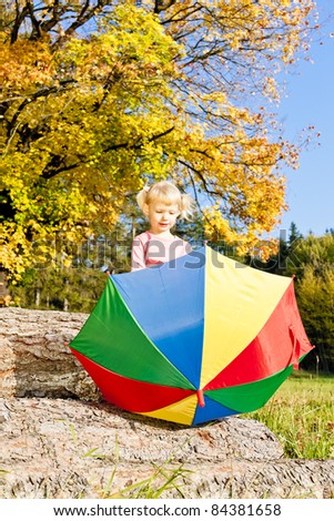 little girl with umbrella in autumnal nature