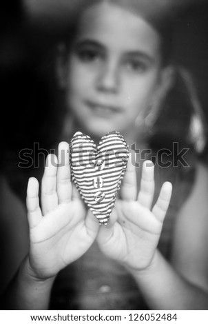 little girl hold a hand-made heart in her hand