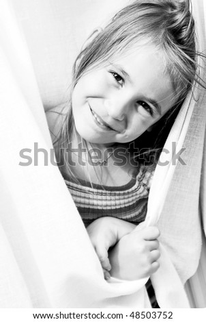 Portrait of little girl playing hide and seek