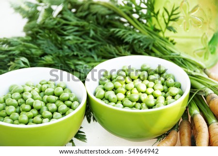 green peas in small green bowl with carrots