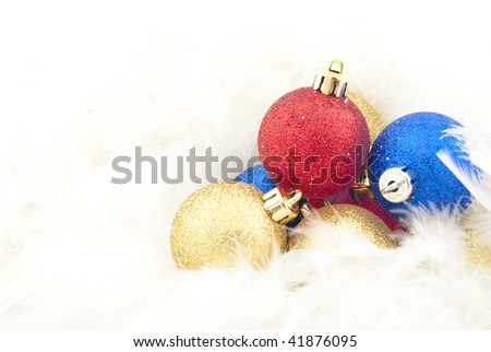 Sparkling Christmas balls among white feathers in the form of snow