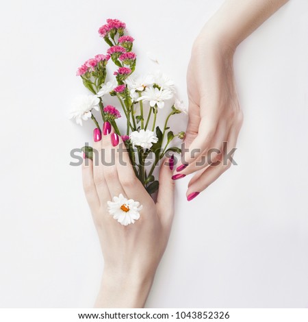 Beautiful well-groomed hands with wild flowers on the table, anti-aging and anti-wrinkle cosmetics for hands. Skin care and beauty, skin hydration and Spa