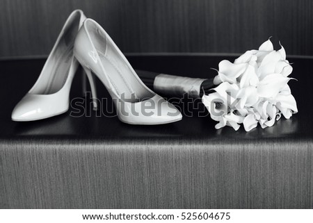 beautiful white wedding bouquet of lilies lies next to the bride\'s shoes