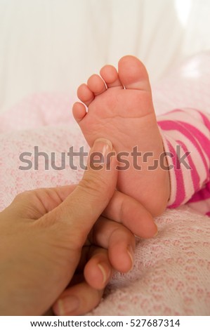 little newborn foot in mother\'s hand holding little foot
