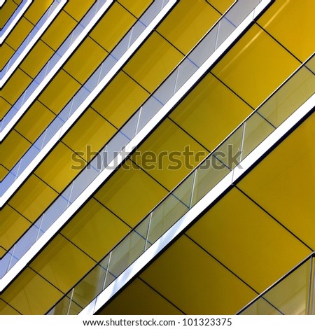 Complex building structural detail, yellow metal bars and glass