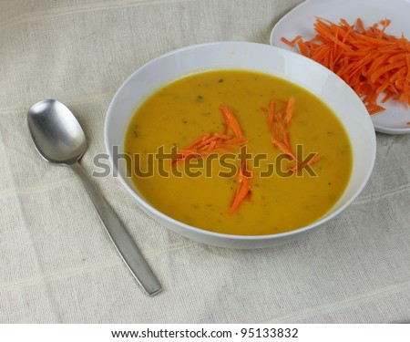 Bowl of coriander and carrot soup with grated carrots