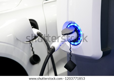 Power supply for electric car charging. Electric car charging station. Close up of the power supply plugged into an electric car being charged