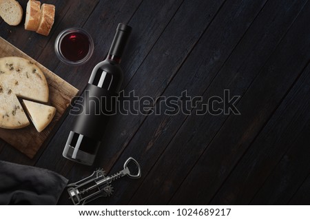Red Wine bottle, corkscrew, cheese, wineglass, bread on black wood background, top view, copy space. Wine bottle mockup. Top view.  3d illustration.