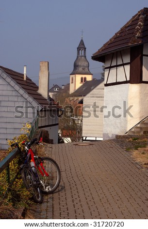 Modern bike in old German town, belltower between traditional old houses, town Heimbach, Germany