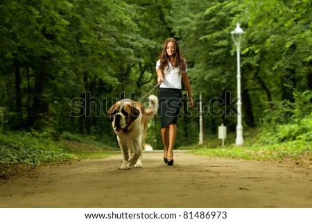 Elegant woman walking her big dog in the park
