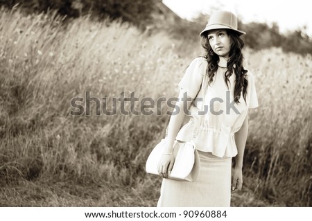 Young woman posing in vintage clothes. Emulation of classic old-style photography.