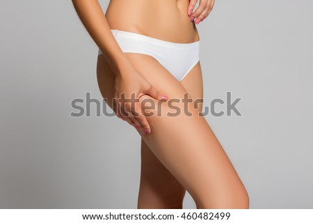Checking cellulite, woman hip, close up of beautiful female body legs belly, perfect figure isolated over white background