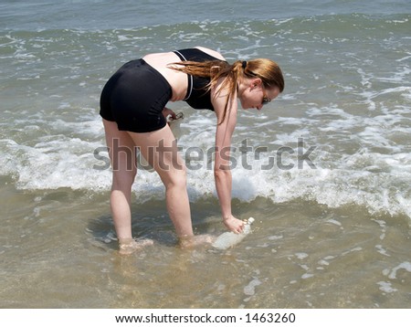 Woman filling a bottle in the sea