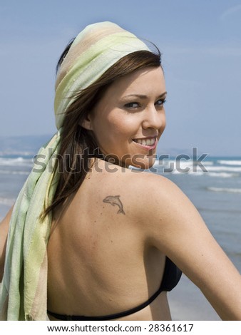 Woman with tattoo by the sea
