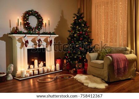 Christmas room interior design, Xmas tree decorated dy lights presents gifts toys, candles and garland lighting indoors fireplace. Christmas holiday living room. New year design.