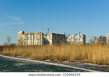 Under construction modern apartment buildings on lake bank in spring (Saint-Petersburg. Russia)