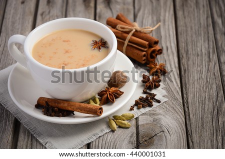 Indian masala chai tea, spiced tea with milk on rustic wooden table, selective focus, copy space