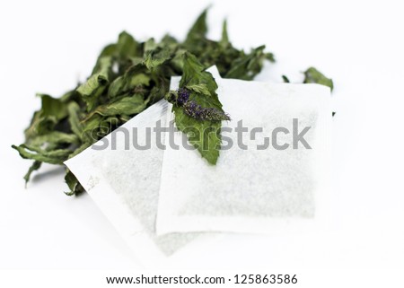 tea bags of dried mint,with dry mint  leaves,on white background .