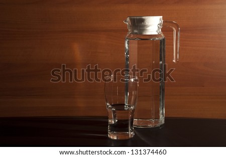 still life with a carafe and a glass of water on a brown background