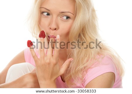 stock photo : Portrait of young woman eating raspberries off fingers 