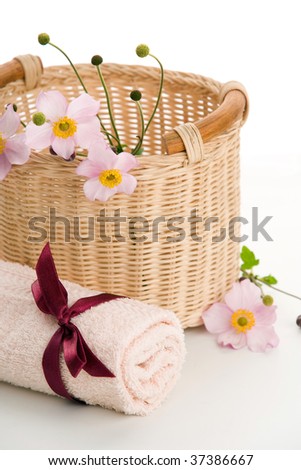 Woven basket, rolled towel and anemones