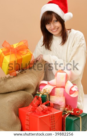 Happy woman sitting on floor with sack of christmas presents