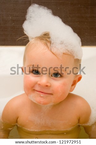 Little boy taking a bath with foam on his head