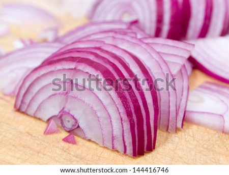 Red onion cuts on a wooden board