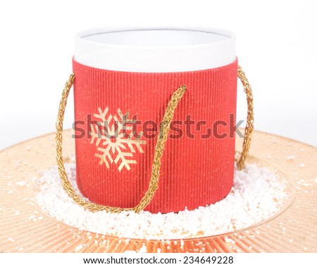 Empty Christmas carton gift box on a golden plate with snow isolated on white background
