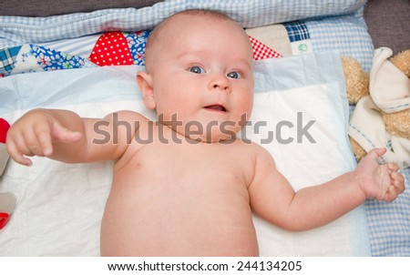 Newborn boy laying on a handmade patchwork blanket
