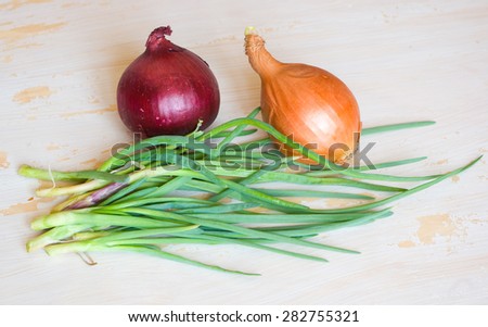 White, green and red onion on a tacky white wooden table