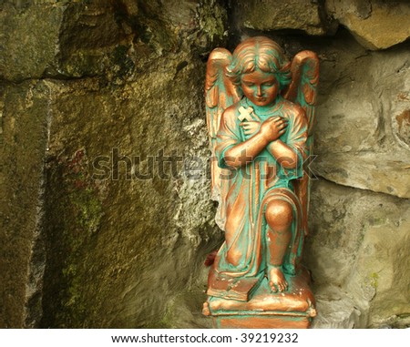 Beautiful figure of angel on wet stone wall