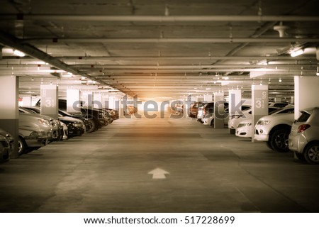 Many cars in parking garage interior, industrial building. Vintage filter effect.