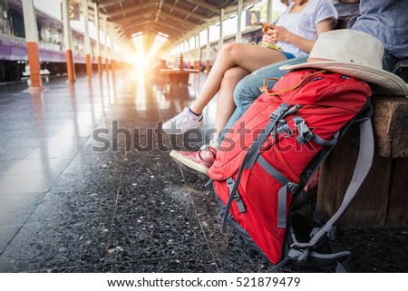 Two backpacker and hat at the train station and looking on the map for plan to travel.  Travel concept.
