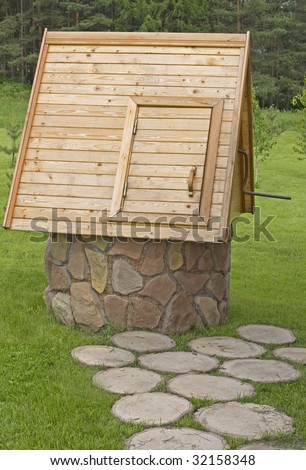 Stone well with wooden roof on the brink of the forest