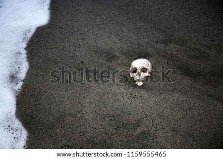 Voodoo Skull. Scary Halloween Skull on a beach with waves. Voodoo Sacrifice at the beach at Sunset.