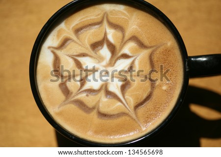 Latte Art, Designs drawn with steamed milk in hot fresh rich coffee in a ceramic coffee cup.