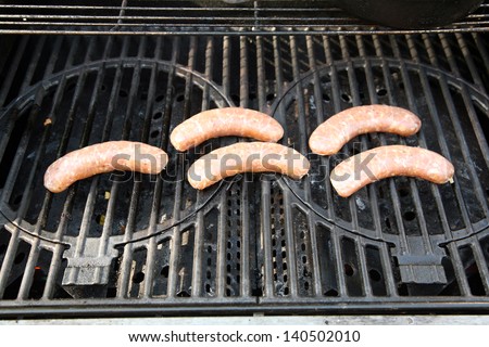 raw Chicken Sausages on a Barbecue Grill ready to be grilled for lunch or dinner or just a special delicious summertime snack