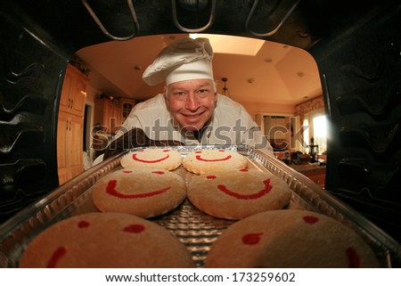 A Man bakes his signature Smiley Face Cookies in his oven for his hungry family and friends. Shot from the Inside of the oven facing out showing a unique view not often seen.