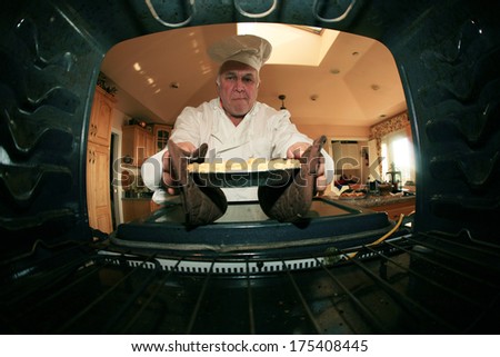 A Man bakes his signature Cherry Pie in his oven for his hungry family and friends. Shot from the Inside of the oven facing out showing a unique view not often seen. Cherry Pies are loved by everyone