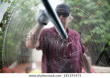A friendly and professional a window washer soaps and cleans a window with a squeegee, leaving them Squeaky Clean. Everyone Loves Clean Windows especially in the Spring and Summer Season.
